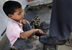 Seorang anak kecil di India bekerja sebagai tukang semir sepatu. foto via mief