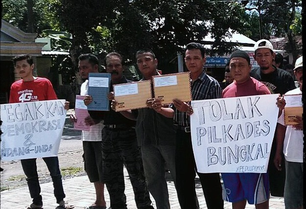 Warga Ponorogo tolak pilkades dengan kirim surat kepada Jokowi dan bentangkan poster protes. Foto Muh Nurcholis/Nusantaranews