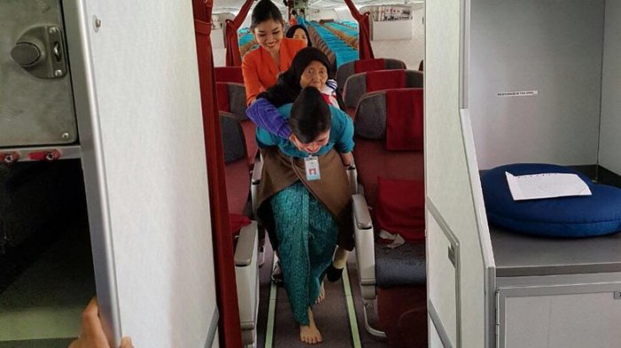 vera sang pramugari saat gendong nenek turun dari pesawat. foto ist
