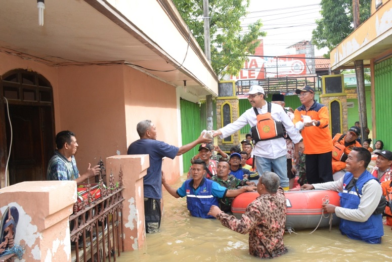 Gus Ipul Berdialog Sambil Memberikan Bantuan Nasi Bungkus Kepada Warga Jl. Panglima Sudirman Sampang Yang Rumahnya terendam Banjir/Foto Tri
