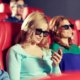 Wanita Melinial asik nonton sesuatu di smartphonenya ketika sedang nonton di bioskop | Polygon
