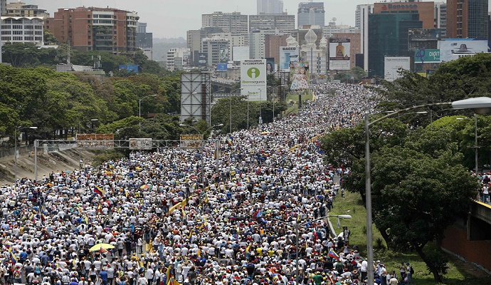 Ribuan demonstran anti-pemerintah berbaris di sepanjang jalan raya di Caracas, Venezuela, menentang Presiden Nicolas Maduro. (Foto: Ariana Cubillos /AP)