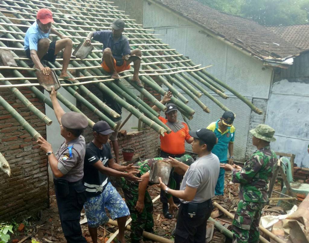Babinsa Sempusari, Jember bersama polisi, warga dan karang taruna perbaiki rumah warga yang tertimpa pohon. Foto: Sis/Istimewa