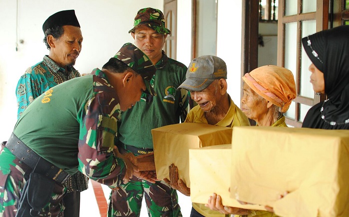 Anggota Koramil Ngetos saat menyerahkan bingkisan kepada warga masyarakat. Foto Timbul/ NusanturaNews