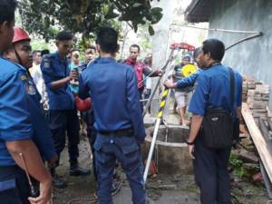 Petugas dari Dinas Pemadam kebakaran bencana Alam Purwakarta sedang mengangkat jenazah nenek apong yang tewas terjun bebas ke sumur. Foto: Fuljo/NusantaraNews