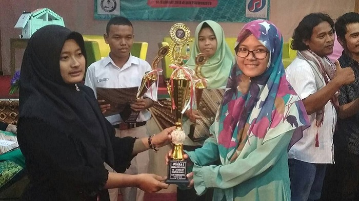 Zahara Nisa Fadila menerima tropi juara I lomba cipta puisi tingkat SMA pertama dan LCP Asean kedua yang diadakan IAIN Purwokerto. Foto: Dimas/ Nusantaranews