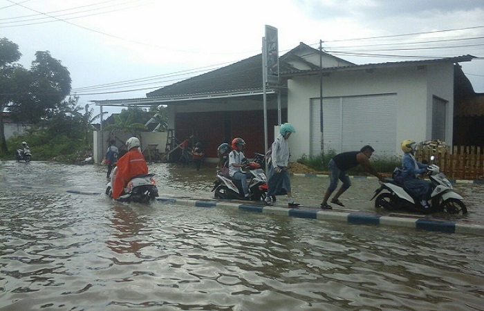 Warga menerobos banjir di Jalan Trunojoyo Sumenep. (Foto: Kafi Hidayat/NusantaraNews)
