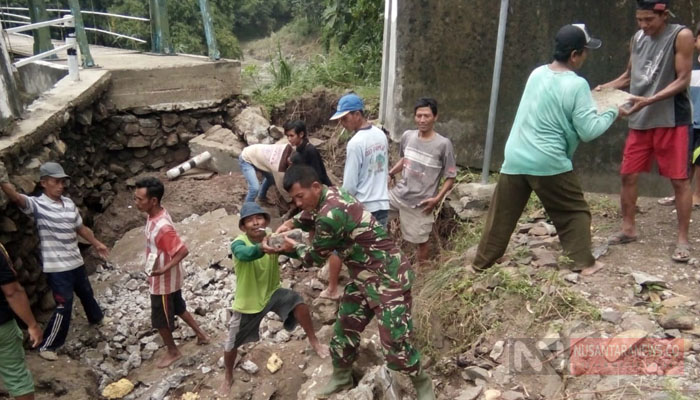 Babinsa Bersama Waga Lakukan Perbaikan Jalan Akibat Diterjang Banjir (Foto Dok. NUSANTARANEWS.CO)