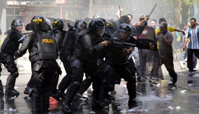 TANPA KOMPROMI: Anggota Brimob bersenjata lengkap menindak tegas para perusuh yang melawan petugas keamanan. (FOTO: NUSANTARANEWS.CO/Han)