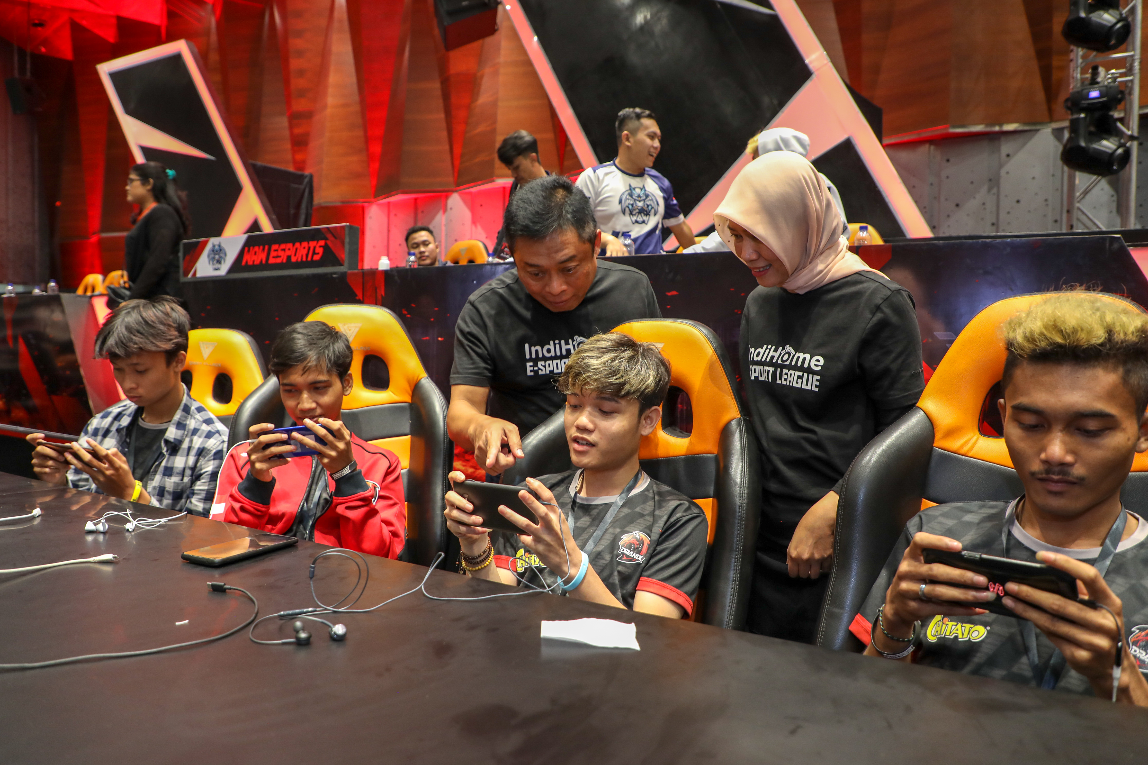 Direktur Utama Telkom Ririek Adriansyah (ketiga dari kiri) dan Direktur Consumer Service Telkom Siti Choiriana (kedua dari kanan) bebincang dengan peserta turnamen saat grand final IndiHome eSports League Games di Jakarta, Jumat (6/12).