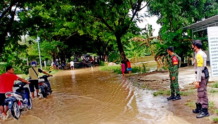 Pantau wilayah terdampak banjir, anggota Koramil 01 Ngawi ingatkan warga tetap waspada.
