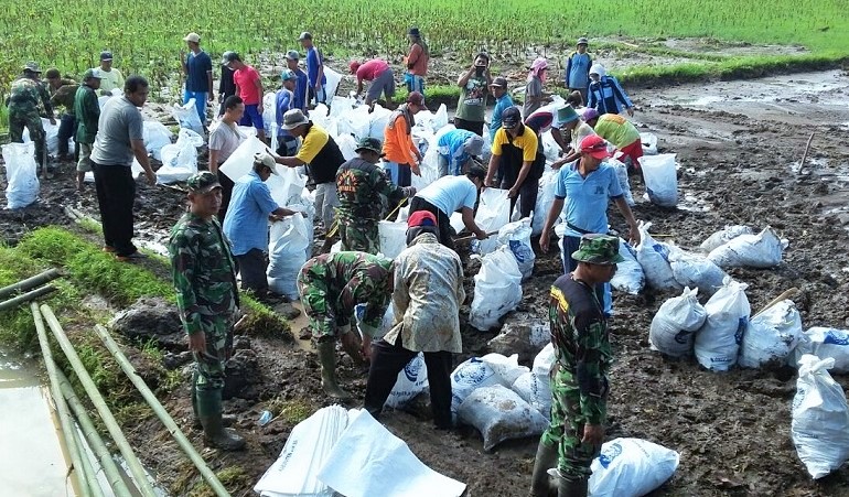 Koramil 0824/23 Bersama Masyarakat Benahi Dinding Irigasi/Foto Sis24