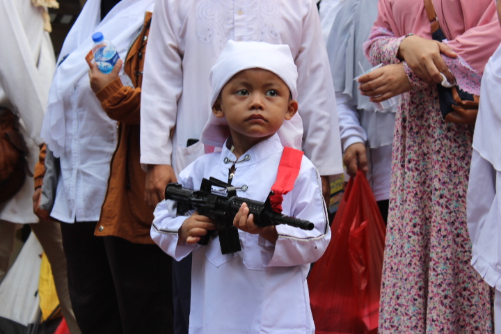 Anak Kecil tampak Sedang membawa pistol mainan dalam aksi 4 November. Foto Andika/Nusantaranews