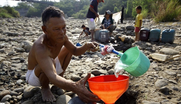 Tampak Seorang Pria Paruh baya sedang mengisi Air. Foto ilustrasi/Tempo