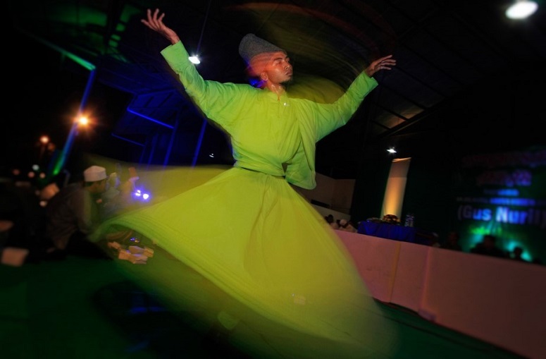 Penari meliuk dalam Tarian Sufi (Whirling Dervishes) dengan diiringi musik hadroh dari Ahbabul Musthofa pada acara Istighosah Akbar di Solo, Jateng, Minggu (20/7) malam. Tarian spiritual asal Turki yang digubah oleh penyair Jalaluddin Rumi ini banyak dipertunjukkan di berbagai acara religi saat bulan Ramadan. ANTARA FOTO/Hafidz Novalsyah