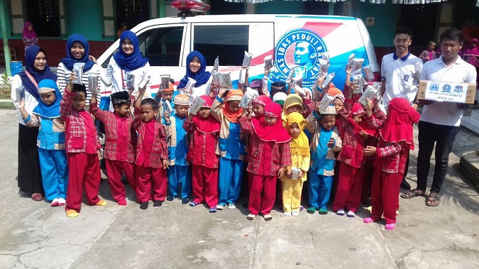 RELAWAN ELANG BIRU EBY MAGETAN MENYERAHKAN BINGKISAN BISKUIT DARI IBAS. (FOTO : MUH NURCHOLIS)