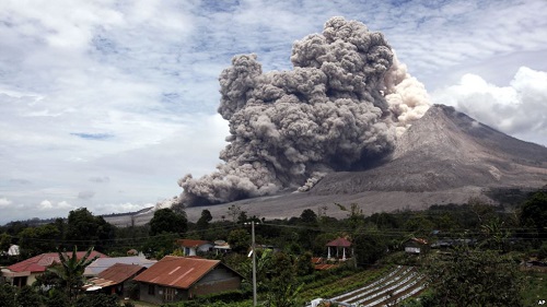 Gunung Sinabung memuntahkan abu vulkanik terlihat dari desa Tiga Serangkai, Sumatra Utara, 1 April 2015. AP Photo/Binsar Bakkara