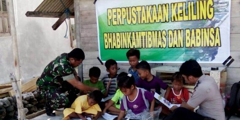 Kopka Sutardi bersama Bhabinkantibmas sedang mengajari anak-anak membaca/Foto Dok. Dispenad/Nusantaranews