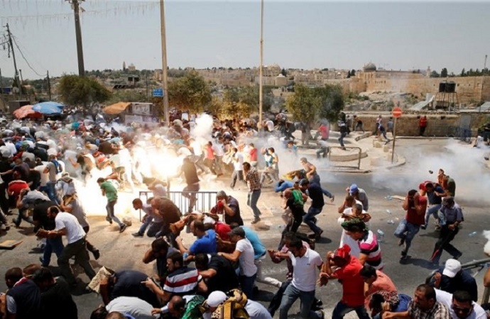 Warga Palestina bereaksi setelah gas air mata yang ditembak oleh pasukan Israel setelah shalat Jumat di sebuah jalan di luar kota tua Yerusalem pada 21 Juli 2017. (Foto: Reuters/Ammar Awad)