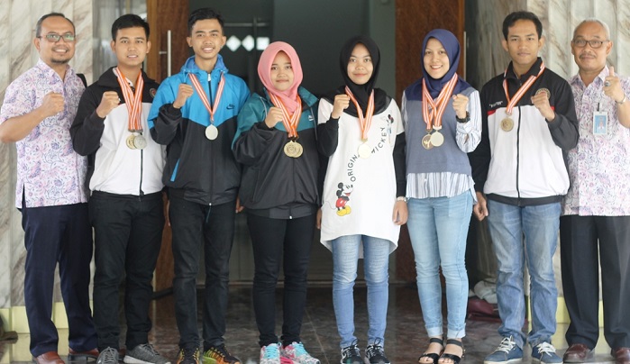 Atlet Tae Kwon Do UMK foro bersama Wakil Rektor III Rochmad Winarso ST. MT. dan pembina UKM Olahraga Ery Budi Kuryanto sembari memperlihatkan medali yang diraihnya. Foto: Humas UMK/ NusantaraNews.co