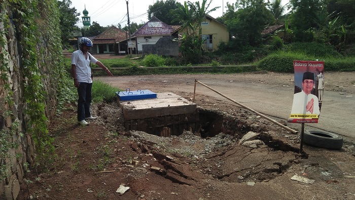 Salah seoranh warga melintas lokasi amblasnya proyek pipanisasi air spam yang telan anggaran milyaran rupiah. (foto fuljo kontibutor Purwasuka)