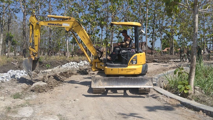 Alat berat eskavator atau bego dari DPU Kabupaten Ngawi dikerahkan dalam pelaksanaan TMMD ke-100 Kodim 0805/Ngawi. Foto Wahyu/ Rantelino