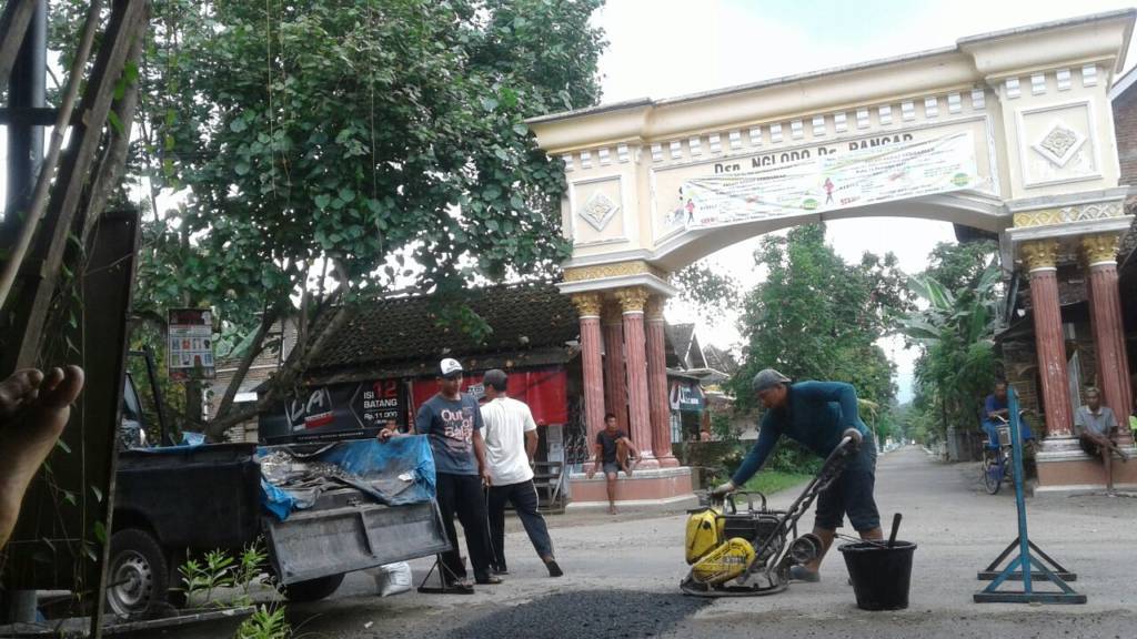 Petugas Dinas Pekerjaan Umum (PU) Pemkab Ponorogo melakukan perbaikan sementara atau penambalan jalan berlubang di sepanjang Jalan Raya Ngasinan-Bungkal, Kamis (11/1/2017). Foto: Muh Murcholis/NusantaraNews