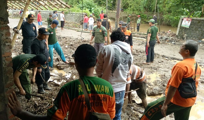 Ratusan anggota Banser dan relawan LPBI NU Kudus melakukan kerja bakti di desa yang terkena banjir. Foto: Istimewa/ NusantaraNews