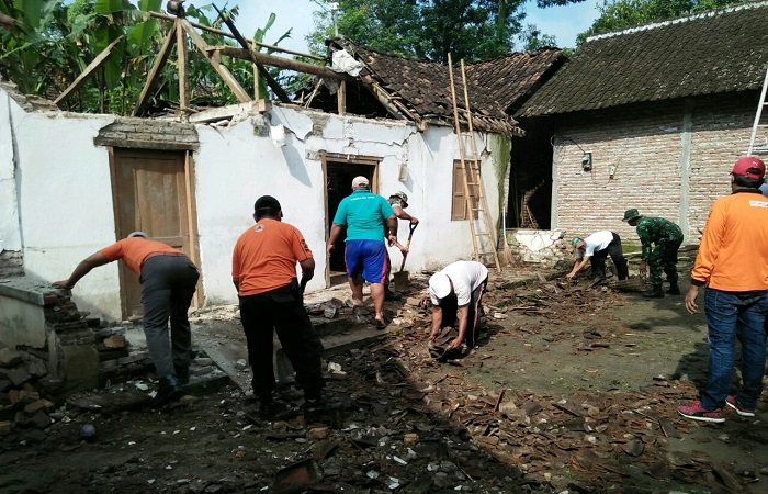 Babinsa, Polsek Jiwan, Muspika Jiwan dan BPBD Kabupaten Madiun serta warga sekitar Desa Teguhan membersihkan rumah warga yang roboh akibat diterjang angin puting beliung. (Foto: Istimewa)