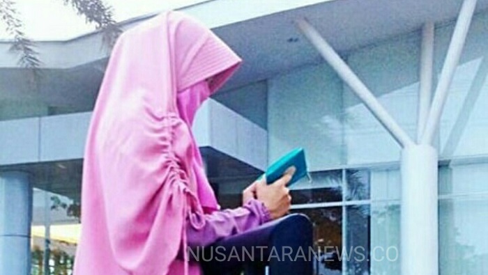 Perempuan Bercadar sedang membaca kitab suci Al-Quran kala senja. (FOTO: NUSANTARANEWS.CO/IG:DL)