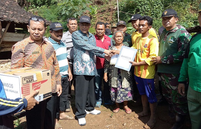 Plt Bupati Nganjuk, KH Abdul Wachid Badrus memberikan bantuan kepada warga yang terkena bencana tanah longsor, Jumat (9/3/2018). (Foto: Istimewa)