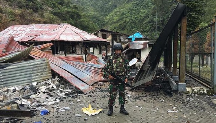 Prajurit TNI berjaga-jaga di dekat sebuah bangunan yang dibakar oleh kelompok Tentara Pembebasan Nasional Papua Barat (TPNPB). (Foto: Puspen Kodam XVII/Cendrawasih)