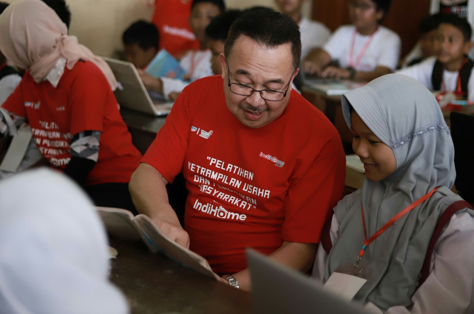 Komisaris Utama Telkom Rhenald Kasali (tengah) memberikan pelatihan internet dasar kepada salah satu siswi Sekolah Dasar dalam program pelatihan keterampilan usaha dan pendidikan masyarakat “IndiHome untuk Indonesia” di Desa Wukirsari, Bantul, Yogyakarta, Senin (9/12).